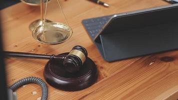 Business and lawyers discussing contract papers with brass scale on desk in office. Law, legal services, advice, justice and law concept picture with film grain effect video