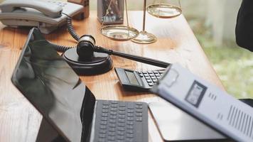 Business and lawyers discussing contract papers with brass scale on desk in office. Law, legal services, advice, justice and law concept picture with film grain effect video