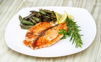 Salmon steak on the plate and wooden background photo