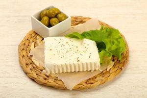 Feta cheese on wooden board and wooden background photo