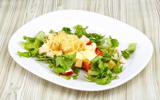 Caesar salad on the plate and wooden background photo