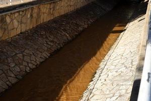 Altas orillas de hormigón de un río tormentoso. foto