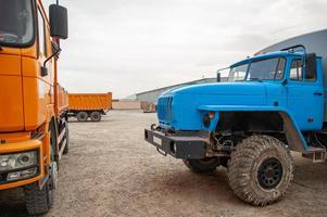 A closeup of an orange and blue dumper trucks in an construction area photo