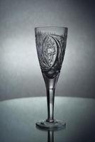 A vertical shot of an empty champagne glass on a grey background