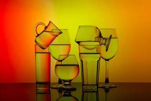 Some glasses for different drinks stacked on a colorful background photo