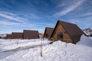 The wooden cottages surrounded by snow. A recreation area in the mountains photo