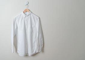 hanging shirt with wood hanger on wall photo