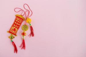 Traditional Vietnamese and Chinese New Year decorations red and golden colors on a pink background, top view. photo