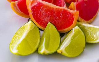 Grapefruits limes grapes lemon citrus fruits on plate Mexico. photo