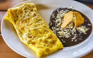 Mexican omelet with black beans and nachos on white plate. photo
