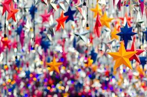 coloridos adornos de estrellas colgando para decorar para las vacaciones de navidad. foto