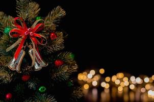 los adornos de campana decoran el árbol de navidad con fondo de luces bokeh. concepto de navidad y año nuevo. foto