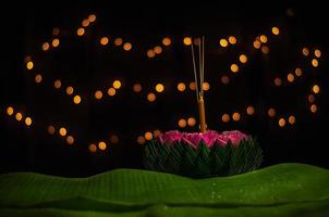 Banana leaf Krathong with 3 incense sticks and candle decorates with pink lotus flower for Thailand Full moon or Loy Krathong festival.