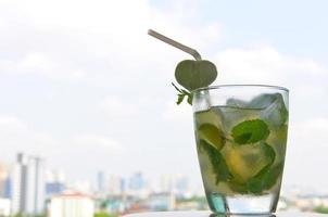 A glass of Mojito cocktail mixing with ice cube, white rum, fresh lime juice, mint leaf, simple syrup and soda. photo