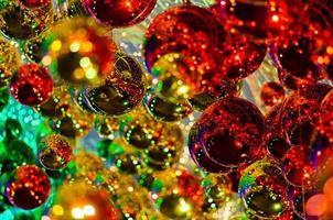 Colorful baubles hanging to decorate for Christmas holiday with colorful bokeh from light and other baubles. photo