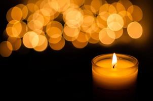 Aromatic candle with flame and round shape bokeh on dark background for Thanks giving and Christmas day. photo