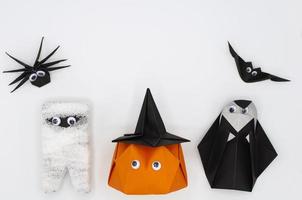The Halloween origami or Paper folding of pumpkin head jack o lantern mummy nun spider and bat isolated on white background. photo