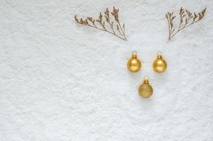 Flat lay of reindeer face with Christmas ornaments and dried tree put on snow background. photo