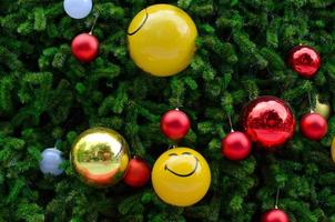 Christmas tree decorates with red, gold and smiling yellow baubles for Christmas holiday photo