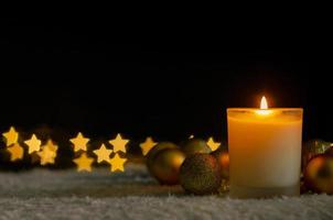 Candle lights and Christmas ornaments with golden star shape bokeh lights. Christmas and New year concept. photo