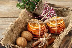 Rustic christmas composition with dried oranges, cinnamon sticks and fir tree branches in a wooden box photo