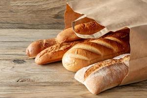 arranged assorted baking products in paper bag on rustic wooden tabletop photo