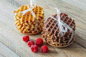 Fresh crisp Belgian waffles with ripe raspberries for breakfast on a wooden rustic table. photo