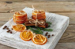 Christmas composition. Arrangement of dry Oranges, cinnamon sticks, fur tree branches and walnuts on wooden background. Rustic, Holiday spices ingredients photo