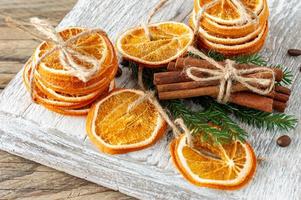 Christmas composition. Arrangement of dry Oranges, cinnamon sticks, fur tree branches and walnuts on wooden background. Rustic, Holiday spices ingredients photo