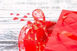 Festive greeting card for valentines day with red gift box and red paper bg. Copy space for text. photo