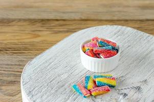 Assortment of chewing marmalade of different colors on wooden desk. Tasty trats for kids. copy space photo