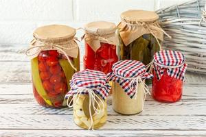 Marinated pickles variety preserving jars. Homemade tomatoes,cucumbers, garlic, ginger and horseradish pickles. Fermented food. photo