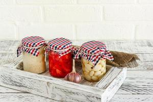 Glass jar with canned garlic, ginger and horseradish. Fermented food on a white background photo