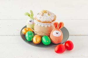 Arrangement decoration Happy Easter holiday background concept. Easter cakeon a plate with handmade knitted eggs. Pastel colors. photo