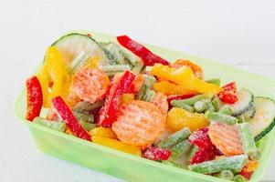 Mix of frozen vegetables in plastic storage containers. Stocks of meal for the winter. photo