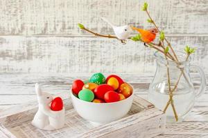 Easter spring composition with painted eggs, ceramics bunny and little birds on twigs. Festive decoration for Easter holidays photo