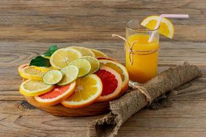 Glasses of juice and citrus fruits on a wooden table. Rustic style. photo