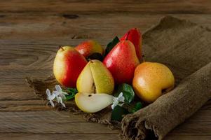 Ripe pears fruit. Harvested organic pear on burlap on wooden table. Autumn harvest. photo