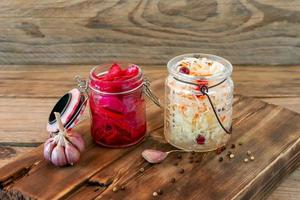 Sauerkraut variety preserving jars. Homemade Sauerkraut with Carrot and Salad Cabbage with Beetroot on a wooden table. Fermented food. photo