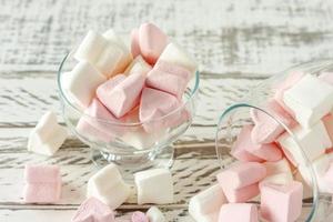 Assorted pink and white marshmallows in glass cups on wooden background. Heart shape marshmallow for hot chocolate or cacao photo