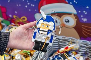 Moscow, Russia, 2020 - Toys at christmas market on display. Festive decoration for christmas tree. Woman hand holding nutckracker. photo