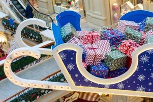 Moscow, Russia, 2020 - Huge sleigh with christmas gifts holdung under ceiling at GUM department store. Festive decoration for winter holidays. photo