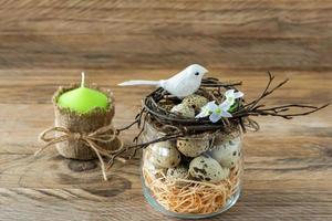 Composition with twig nest, quail eggs and small birds. Easter holidays in rustic style photo