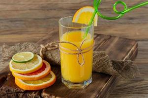 Glasses of juice and citrus fruits on a wooden table. Rustic style. photo