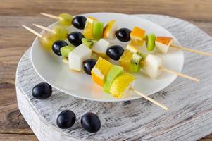 mesa de catering con canapés de ensalada de frutas. bocadillos de entrada foto