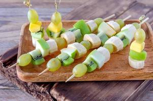 canapés de frutas para un buffet en un plato. dulces para unas vacaciones, aniversario, cumpleaños. foto