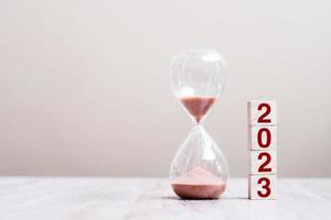 Texto de 2023 con reloj de arena en la mesa. resolución, tiempo, plan, objetivo, motivación, reinicio, cuenta regresiva y conceptos de vacaciones de año nuevo foto