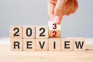 hand flipping block 2022 to 2023 REVIEW text on table. Resolution, idea, goal, motivation, reboot, business and New Year holiday concepts photo