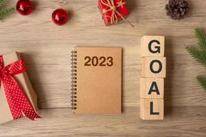 2023 New Year with notebook, Christmas gift and pen on wood table. Xmas, Happy New Year, Goals, Resolution, To do list, start, Strategy and Plan concept photo