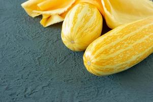 yellow zucchini on grey background in colors of the year 2021 - Illuminating yellow and ultimate grey photo